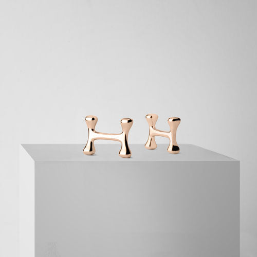 H-OS rose gold cufflinks on a stand